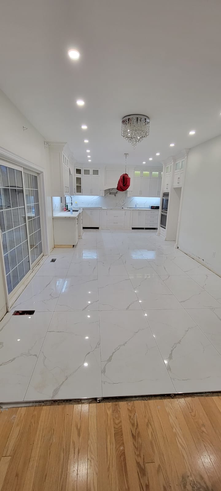 Polished Calacatta porcelain kitchen floor with chandelier