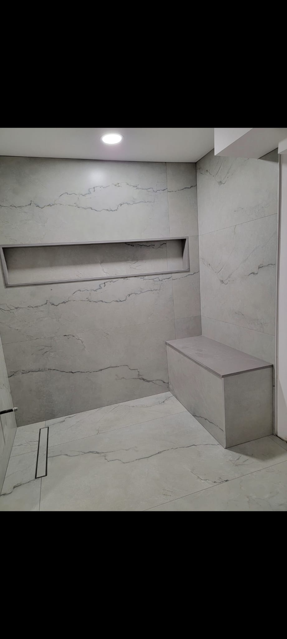 Custom grey shower with bench and niche