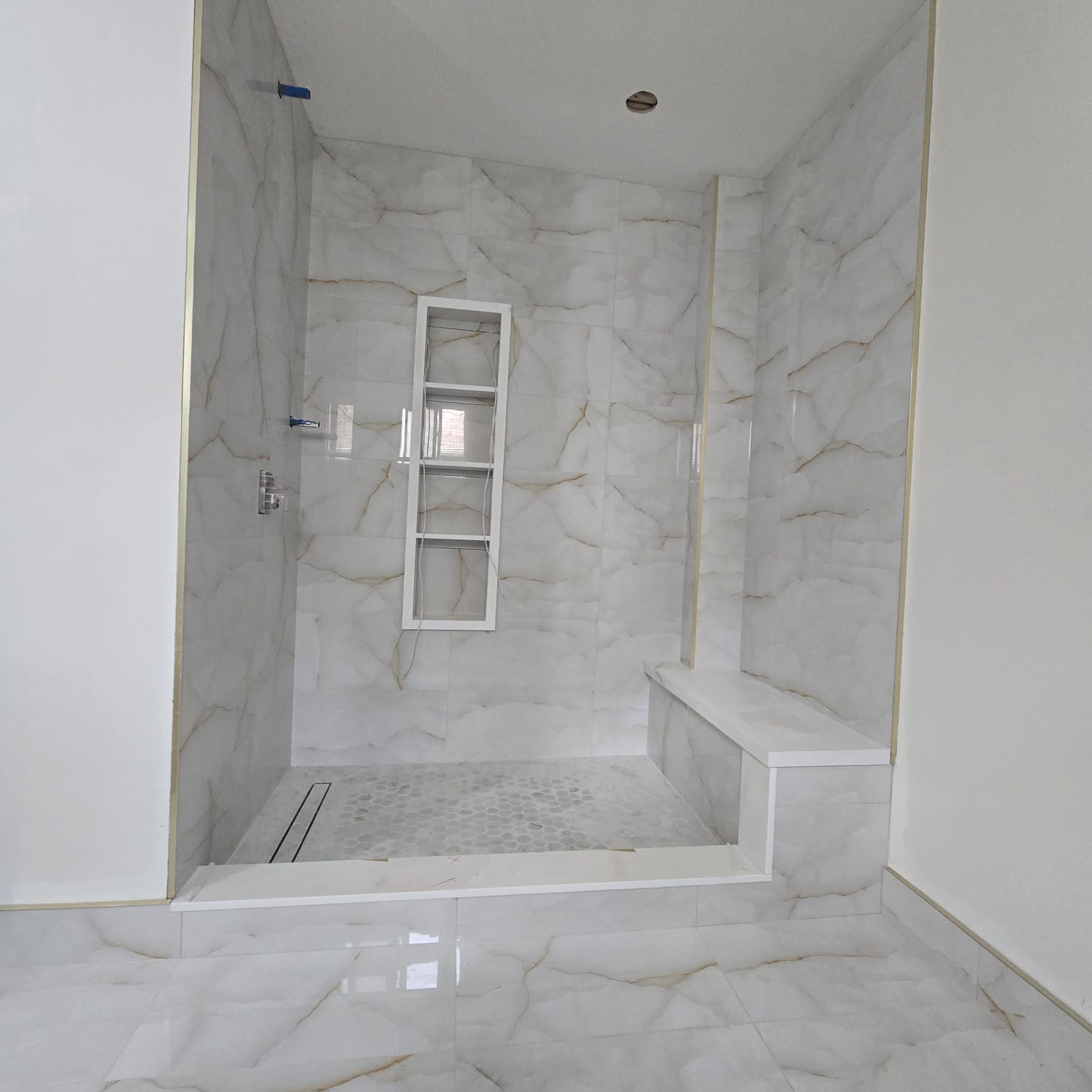 Calacatta marble shower with bench seat and hex mosaic floor