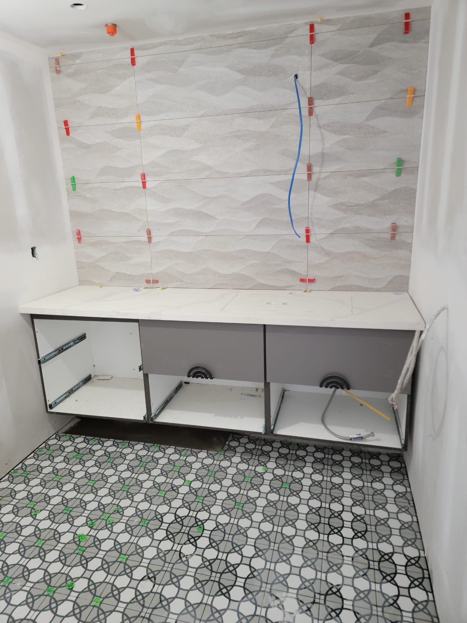 Bathroom with patterned floor and textured wall tile